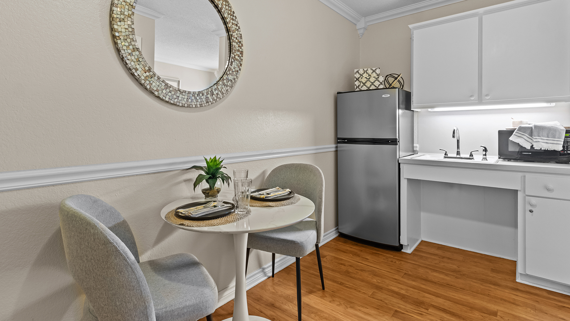 Atria Copeland senior apartment kitchenette with settee and stainless steel refrigerator