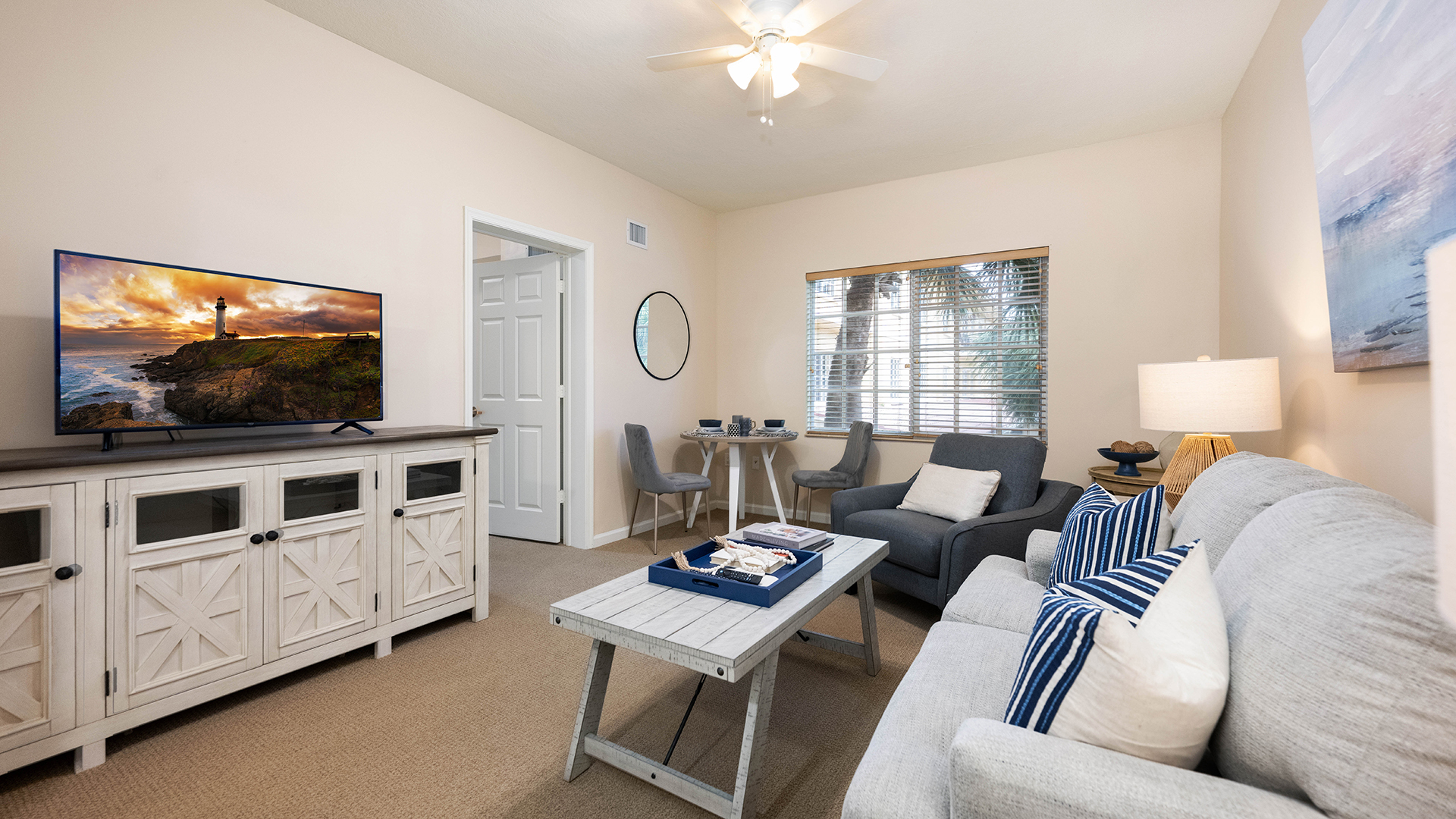 Apartment model living room with tv, entertainment center, coffee table, and couch.