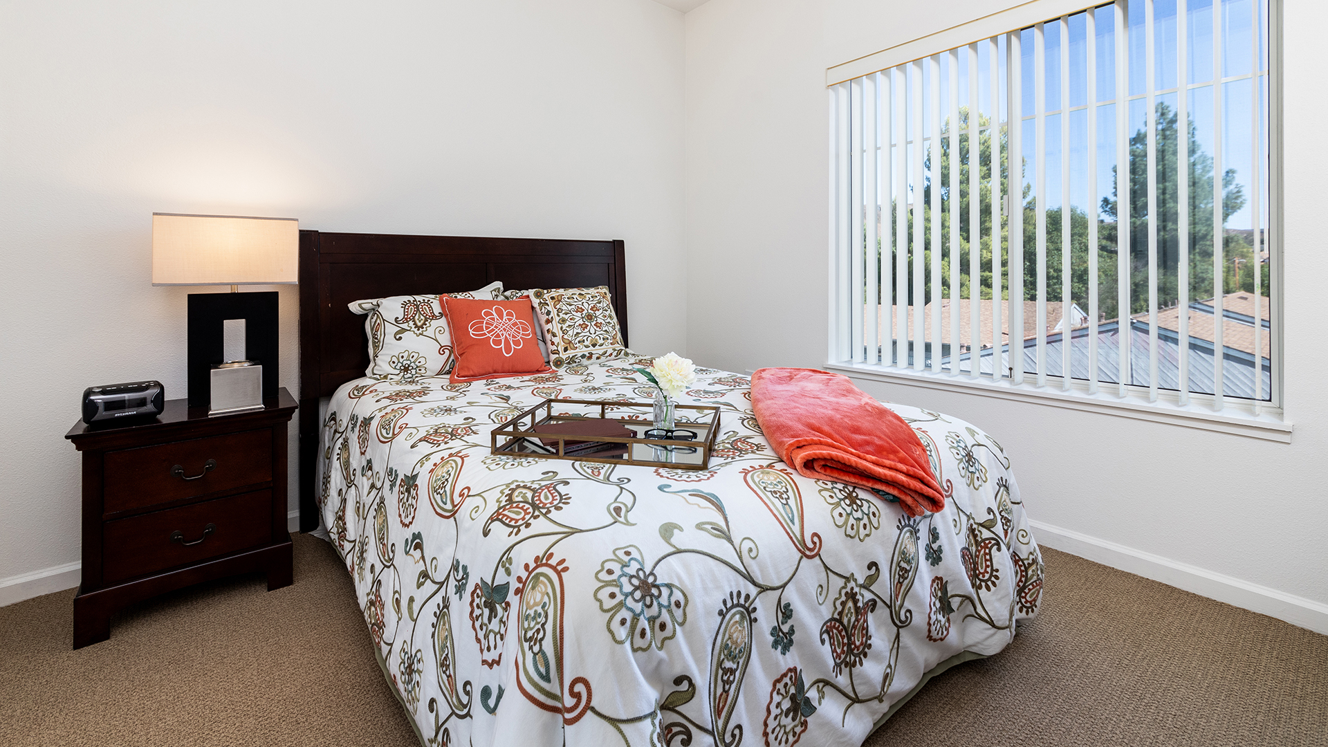 Apartment bedroom with a breakfast table atop a floral decorated bedspread