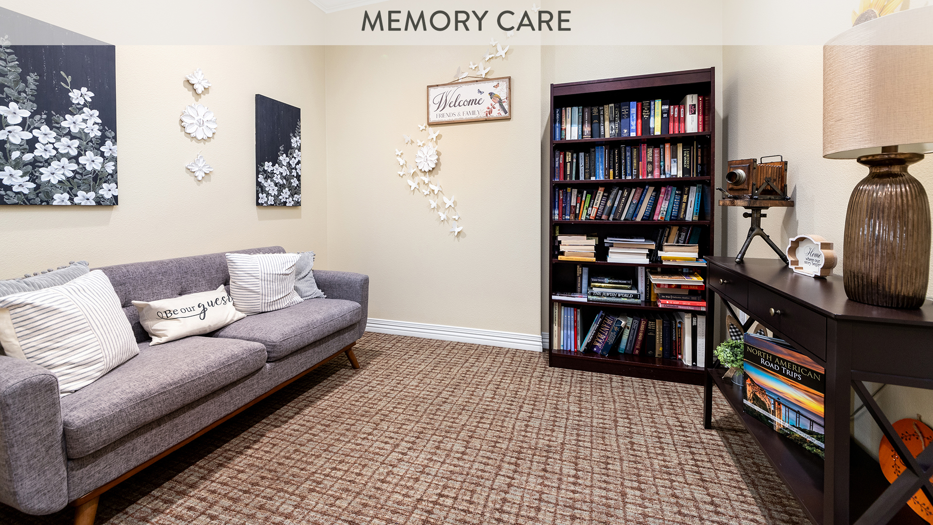 Memory care apartment living room with sofa and bookshelves