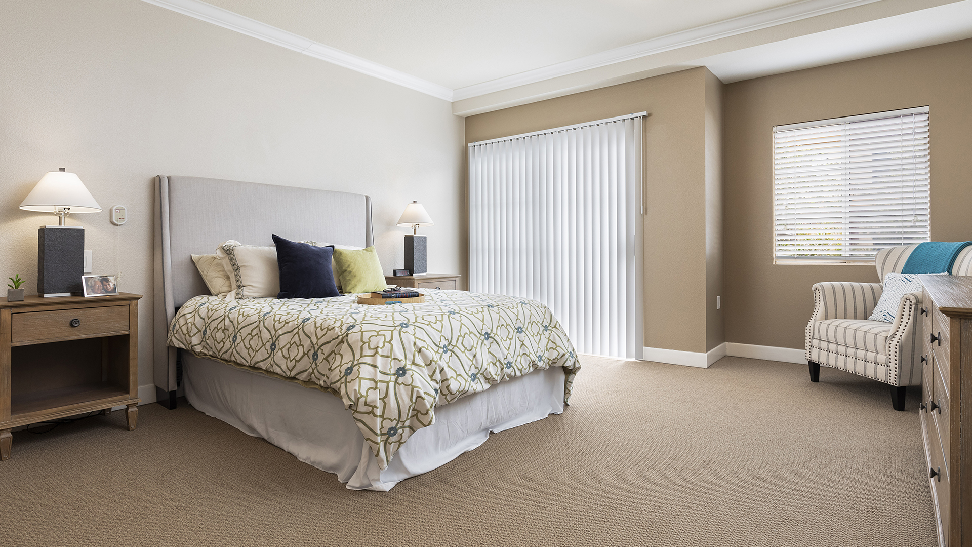 apartment model bedroom with queen sized bed and large windows
