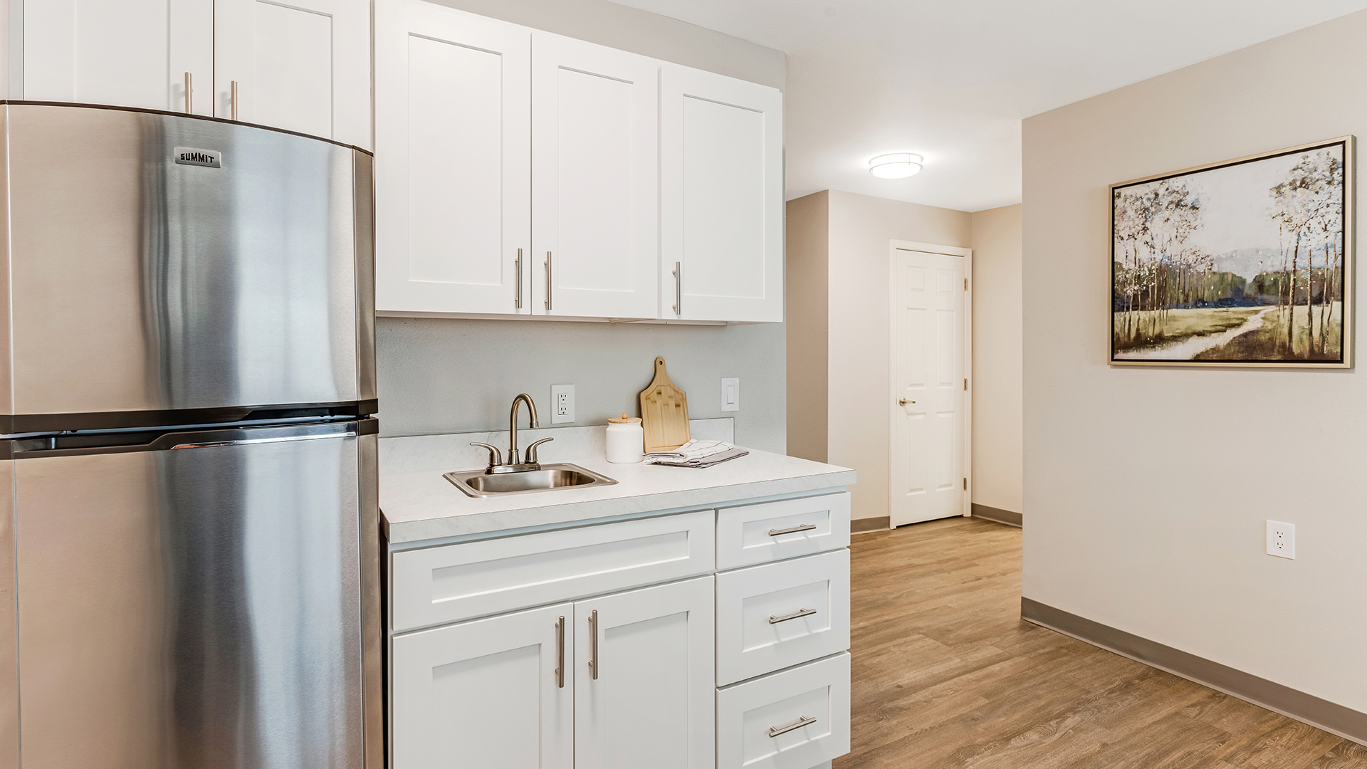 apartment kitchen with stainless steel refrigerator and sink