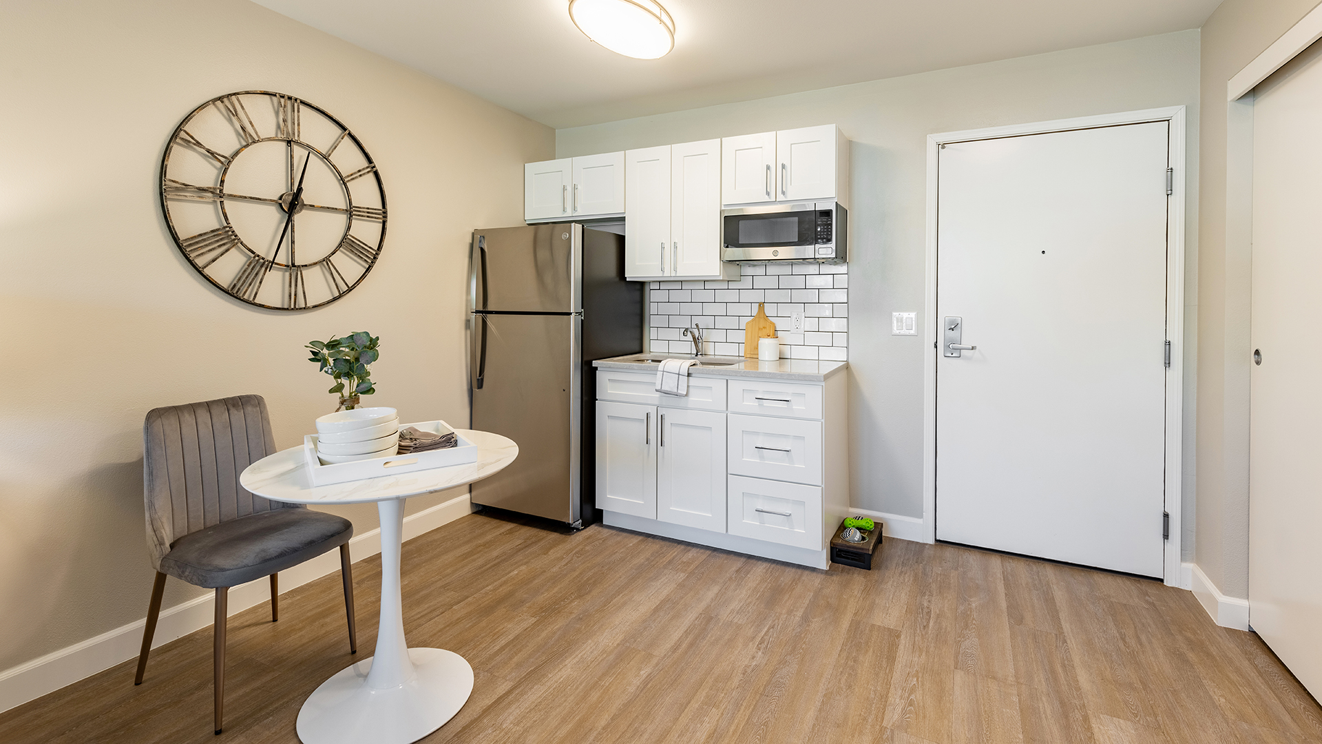Holiday Chateau at Harveston apartment kitchenette with stainless refrigerator, sink, and microwave with small dining table