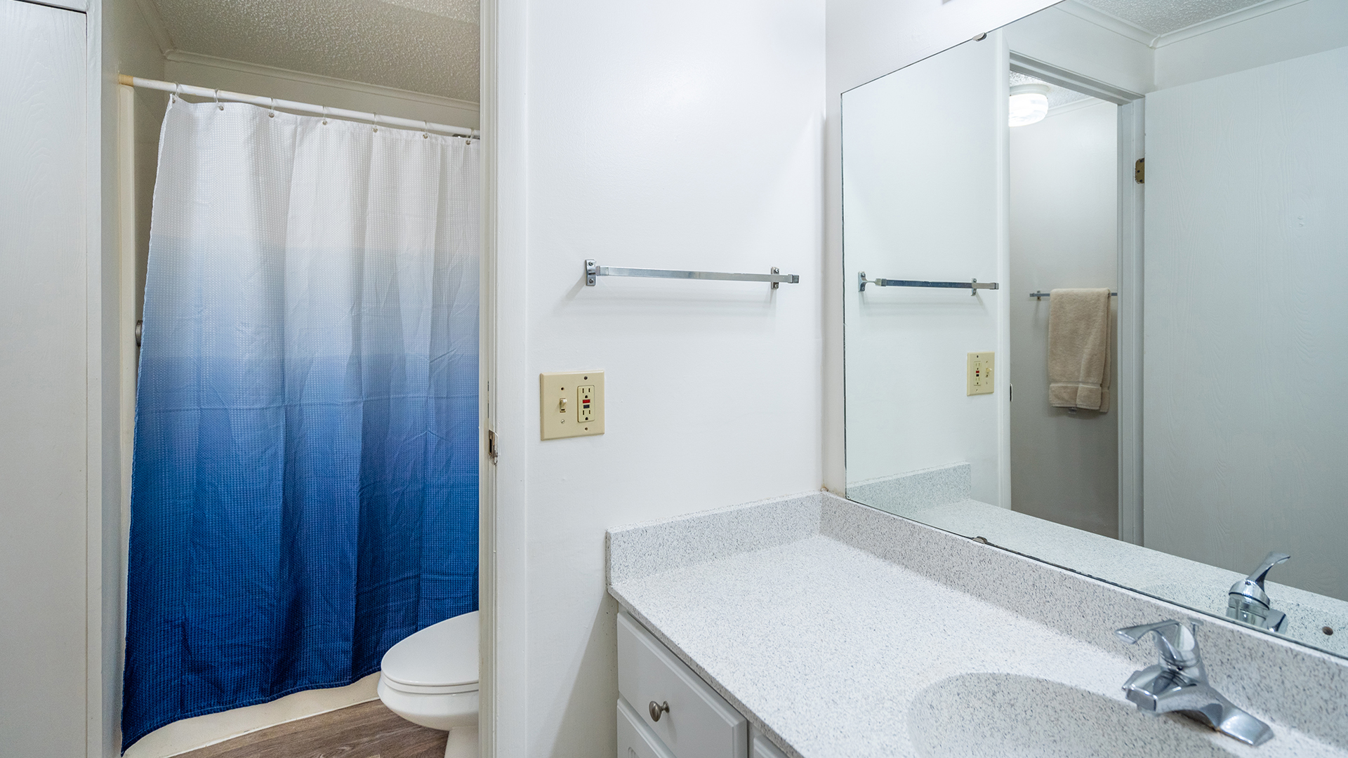 apartment bathroom with full sized walk-in shower, vanity, and toilet